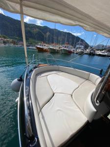 a boat in the water with boats in a harbor at Boka Boat Tours in Kotor