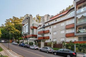 a street with cars parked in front of a building at L'Adresse Réserve 150m R Coberta by Achei Gramado in Gramado