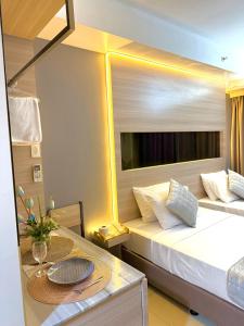 マニラにあるAiza's Place with Two Beds in Shell Residences PASAY near MOA and NAIAのベッド1台、テーブル(皿付)が備わる小さな客室です。