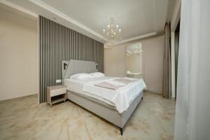 a bedroom with a large white bed and a chandelier at Villa Tivat in Tivat