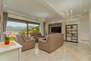 a living room with two chairs and a television at Villa Tivat in Tivat
