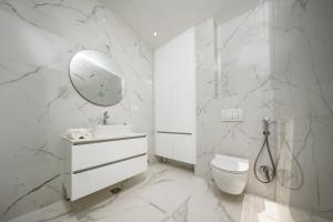 a white bathroom with a toilet and a mirror at Villa Tivat in Tivat +14 photos