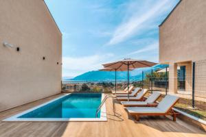 a swimming pool with lounge chairs and an umbrella at Villa Tivat in Tivat