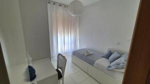 a bedroom with a bed and a table and a window at Apulia Beach in Leporano
