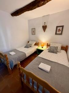 a bedroom with two beds and a green table at Gîte Citronnier Authentique et paisible in Maureillas +34 photos