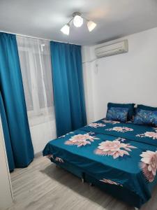 a bedroom with a bed with a blue comforter at Gara De Nord 3 Rooms Apartment Superb City View in Bucharest