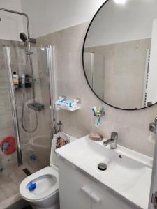 a bathroom with a sink and a mirror and a toilet at Gara De Nord 3 Rooms Apartment Superb City View in Bucharest +19 photos