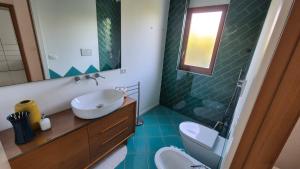 a bathroom with a sink and a toilet and a mirror at Apulia Beach in Leporano