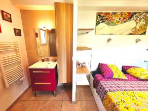 a bathroom with a bed and a sink in a room at Suréquipée avec cuisine extérieure, climatisation in Pontcharra