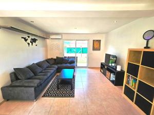 a living room with a couch and a tv at Suréquipée avec cuisine extérieure, climatisation in Pontcharra