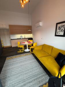 een woonkamer met een gele bank en een tafel bij Sunny Jantar in Jantar