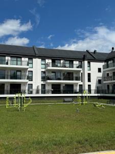 een appartementencomplex met een speeltuin voor een gebouw bij Sunny Jantar in Jantar