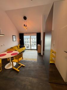 een woonkamer met een gele bank en een tafel bij Sunny Jantar in Jantar