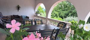 a balcony with a table and chairs and flowers at Apartment Nevija e Natale in Opric