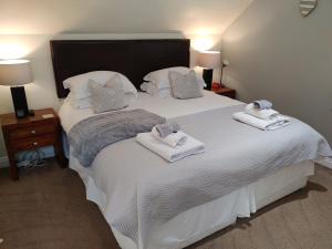 une chambre avec un grand lit blanc avec des serviettes dessus dans l'établissement The Bath House Apartments - Free 1st breakfast - FREE parking, à Bath