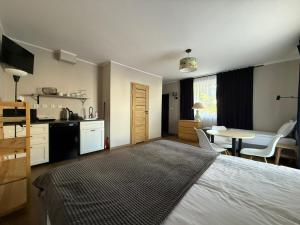 a bedroom with a bed and a kitchen and a table at Dom na Północy in Władysławowo