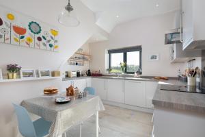 a kitchen with white cabinets and a table and chairs at Shepherds View at Dufton Barn Holidays in Dufton