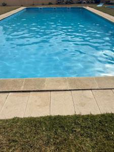 a swimming pool with blue water and a sidewalk at Apartamento LUZ DA PRAIA in Vila Chã