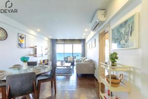 a dining room and living room with a table and chairs at Sea View Apartment with Pool - Relax by the Coast in Larnaka
