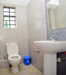 a bathroom with a toilet and a sink at Davinia Haven in Nairobi +6 photos