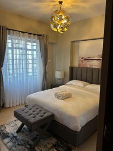 a bedroom with a large bed and a chandelier at Davinia Haven in Nairobi