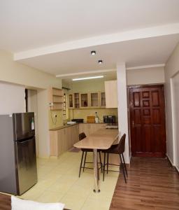 a kitchen with a wooden table and a refrigerator at Davinia Haven in Nairobi