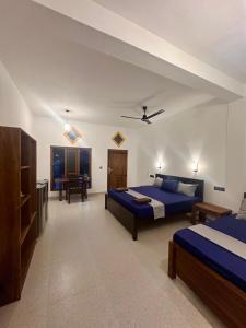 a large room with two beds and a table at Harmony Beach Hotel in Arugam Bay +51 photos