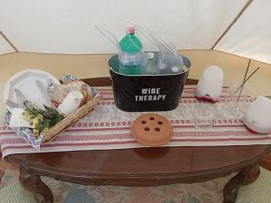 a table with a container of wine therapy on it at Tenda romantica nel Noccioleto in Castellero