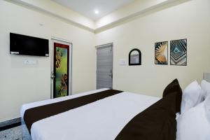 DānāpurにあるHotel O A.V.Sのベッドと薄型テレビのある寝室