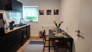 una cucina con tavolo e una piccola cucina con lavandino di Stylisches City Apartment im Pott Modern und Gemütlich a Gelsenkirchen