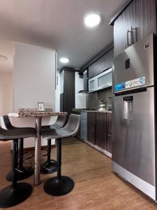 a kitchen with a table and a refrigerator at Apartamento zona Hesperia Sambil Complejos Deportivos in Naguanagua