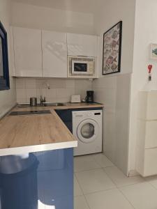 eine Küche mit Waschmaschine und Mikrowelle in der Unterkunft Sama Fisherman House in La Playa de Arguineguín