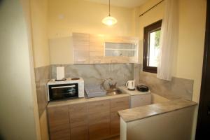 a small kitchen with a microwave and a refrigerator at Mouse Island View Studios in Perama