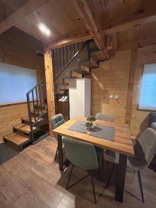 a dining room with a table and a staircase at Wooden Villa Old Oak Plitvice Lakes in Seliste Dreznicko