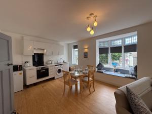 a kitchen and dining room with a table and chairs at Modern Town Centre Flat in St Austell