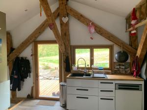 a kitchen with a sink and a wooden ceiling at Chalet Sauce Montagnarde in Planay