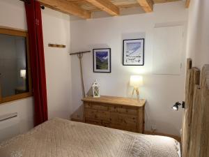 a bedroom with a bed and a table with a lamp at Chalet Sauce Montagnarde in Planay