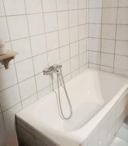 eine Badewanne mit Dusche in einem weiß gefliesten Badezimmer in der Unterkunft CasaPortitsa in Spílaion + 49 Fotos