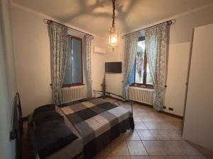 a bedroom with a bed and two windows at Mia Experience Lake Como in San Fermo della Battaglia