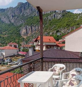 ein Balkon mit Tisch und Stühlen und einem Berg in der Unterkunft CasaPortitsa in Spílaion