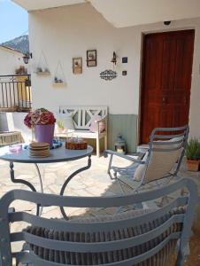 eine Terrasse mit Tisch und Stühlen in der Unterkunft CasaPortitsa in Spílaion