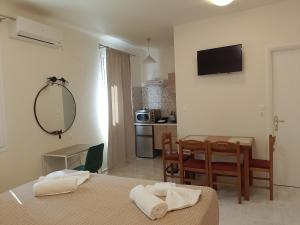 a room with two beds and a table and a kitchen at Euphoria City Homes in Argostoli