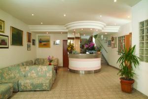 a lobby with a waiting room with a couch and a counter at Hotel Tre Grazie in Rimini