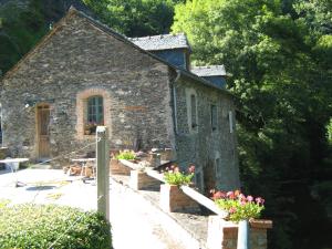 une ancienne église en pierre avec des fleurs devant elle dans l'établissement Auberg'IN Gîte, à Mirandol-Bourgnounac