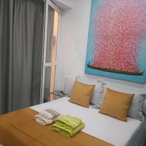 a bedroom with a bed with two towels on it at Escapada junto a Picasso in Málaga