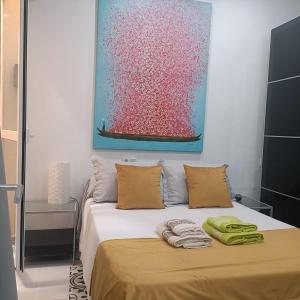 a bedroom with a bed with a painting on the wall at Escapada junto a Picasso in Málaga
