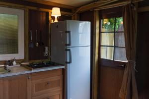 a white refrigerator in a kitchen with a window at JABUTI Autocaravana con porche y aparcamiento in Cádiz