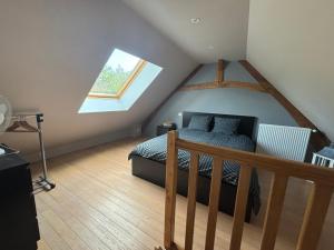 a attic bedroom with a bed and a window at Le magnolia in Épieds