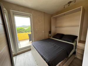 a small bedroom with a bed and a window at L'endroit in Bormes-les-Mimosas