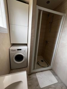 a bathroom with a washing machine and a shower at L'endroit in Bormes-les-Mimosas